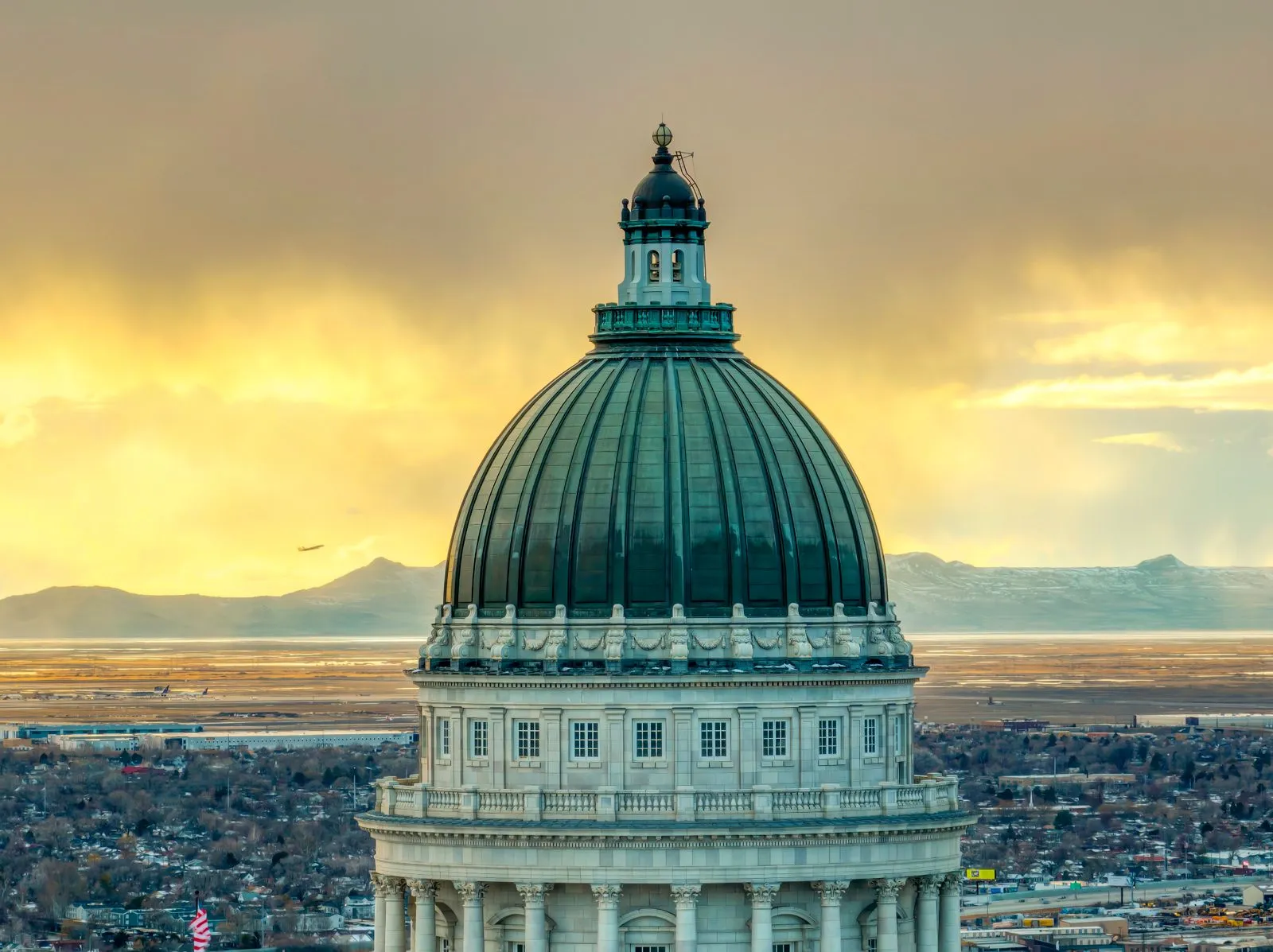 Majestic view of the Utah State Capitol dome with a vibrant sunset backdrop in Salt Lake City.